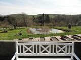 Gårdhyttens terrasse med udsigt til vores sø